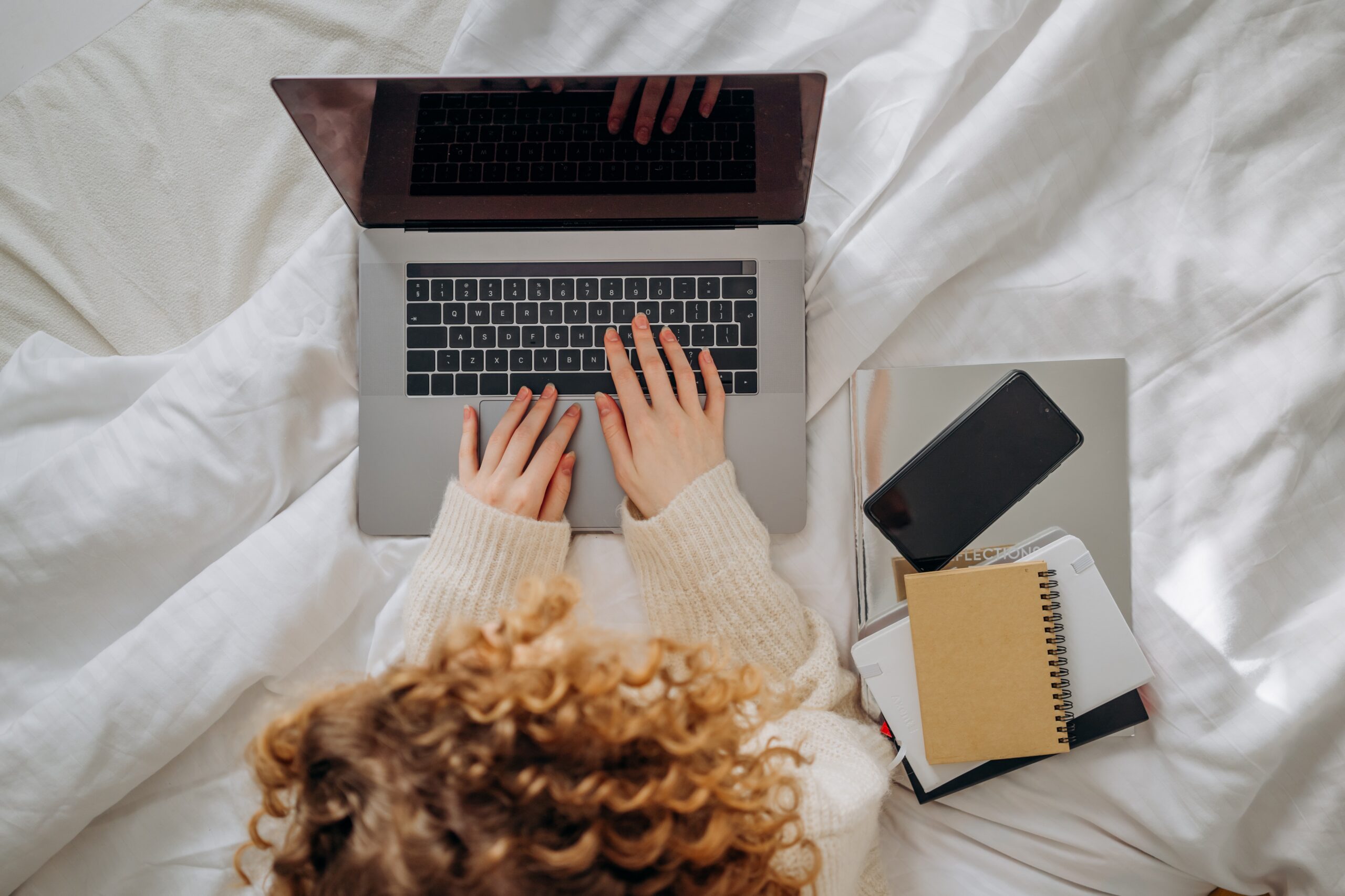 Person som sitter i säng med laptop